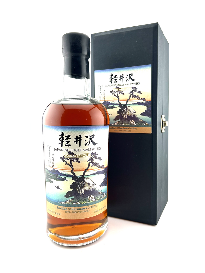 A bottle of Karuizawa whisky with a label featuring a serene lake scene, part of the 36 Views of Mount Fuji series, in front of a black box with Hokusai's artwork.